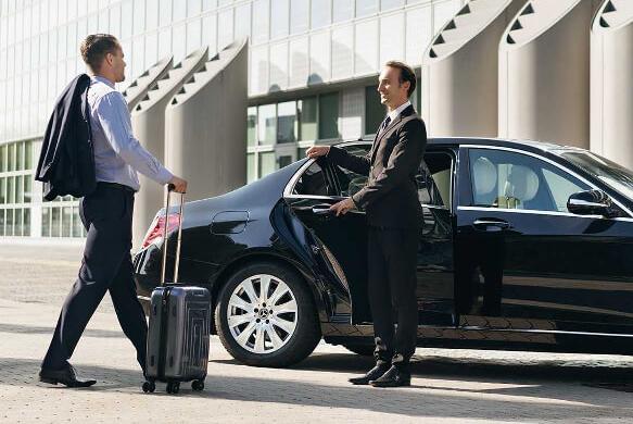 Luxury sedan waiting for passengers at Chennai International Airport arrivals.